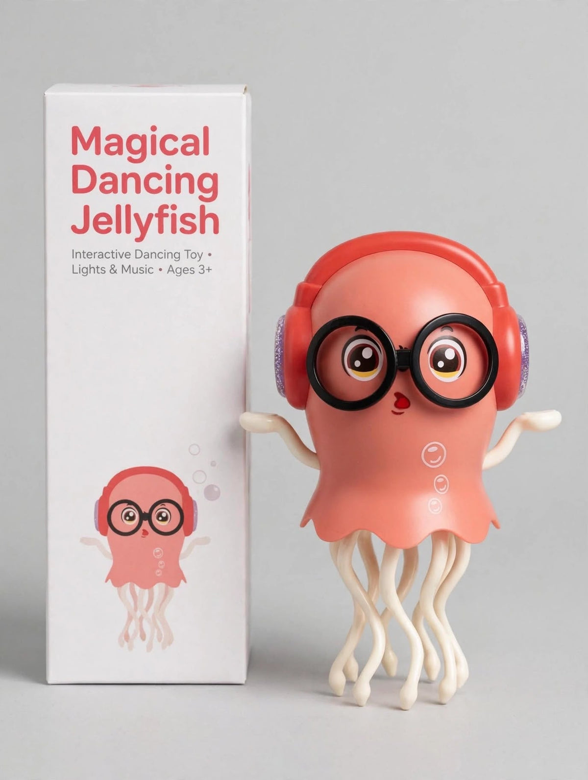 Pink dancing jellyfish toy with red headphones and black glasses beside its retail packaging.