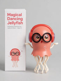 Pink dancing jellyfish toy with red headphones and black glasses beside its retail packaging.