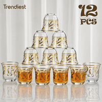 Glass coffee cups with gold Arabic calligraphy arranged in a pyramid