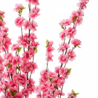 Trendiest artificial cherry blossom tree branches with vibrant pink flowers and green leaves on a white background.