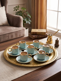 Trendiest decorative ceramic Turkish coffee cup and saucer set in light blue with gold rims on a gold serving tray.