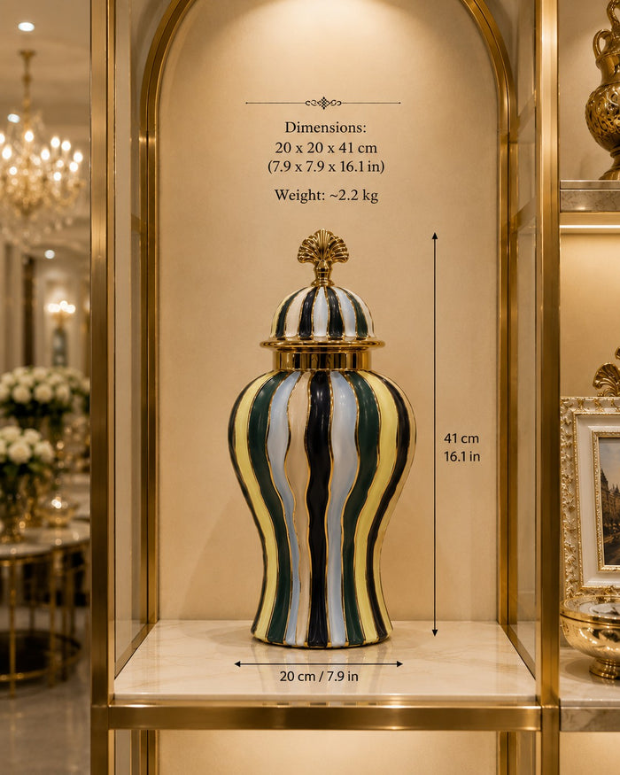 Trendiest ceramic urn vase with gold, emerald green, navy, and ivory stripes and a decorative lid on a display shelf.