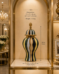 Trendiest ceramic urn vase with hand-finished gold, emerald, navy, and ivory oil paint stripes on a display shelf.