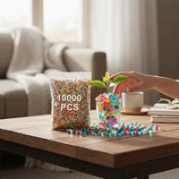 Trendiest Gell Orbeez water bomb beads in a bag and glass vase with a small plant on a wooden table