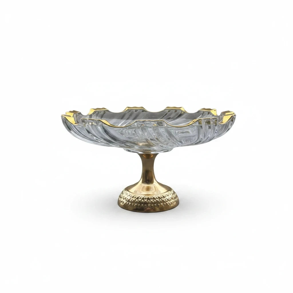 Trendiest glass serving bowl with a gold-tone rim and an intricately detailed pedestal base on a white background.