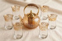 Trendiest borosilicate glass teapot with floral embossing, gold infuser, and wooden handle with five matching cups.