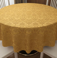 Trendiest round gold tablecloth with an intricate damask textured pattern draped over a dining table