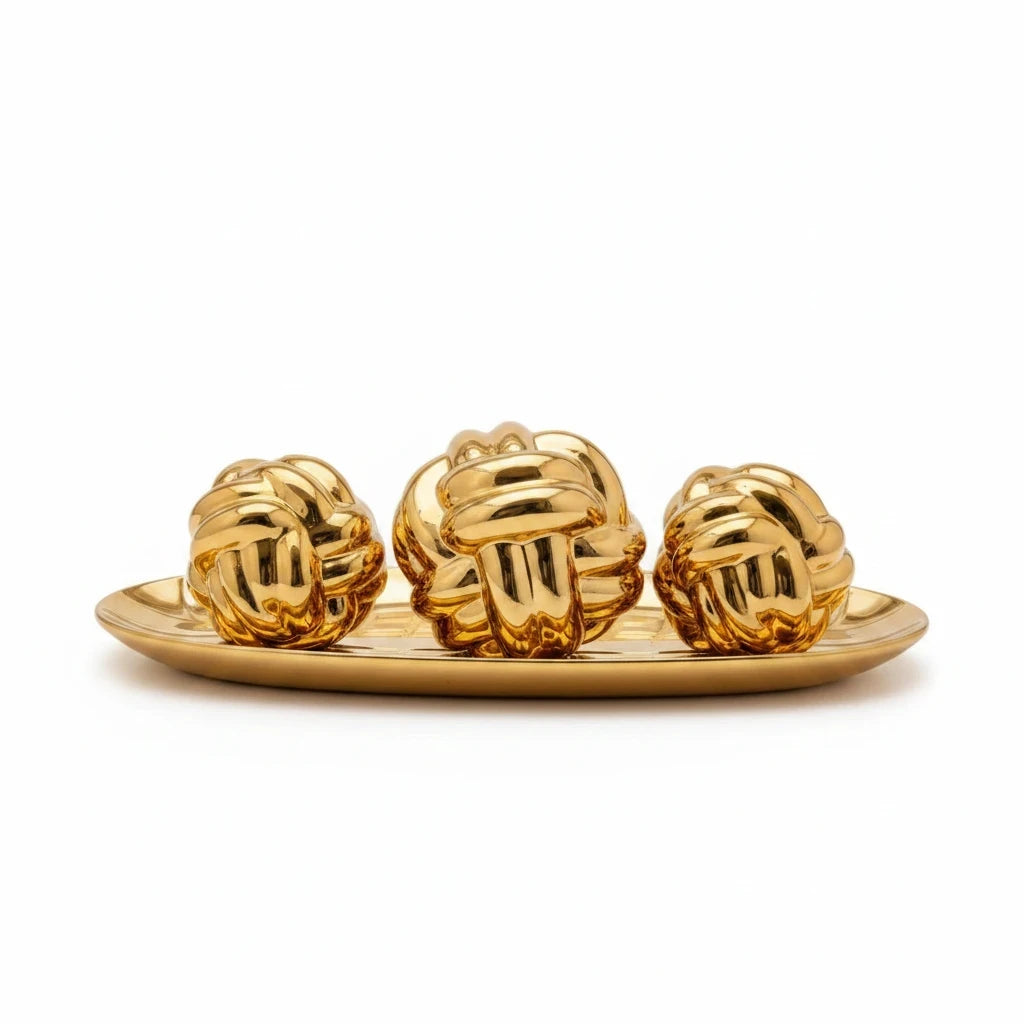 Trendiest decorative gold knot sculpture set featuring three polished spheres on an oval display tray.
