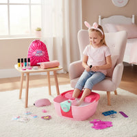 Trendiest kids home spa set with a girl wearing bunny ears using a pink foot soak tub, nail polish, and accessories.