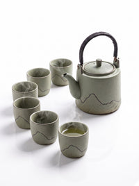Trendiest high-fired porcelain tea set in sage green with a mountain motif, including a teapot and six matching cups.