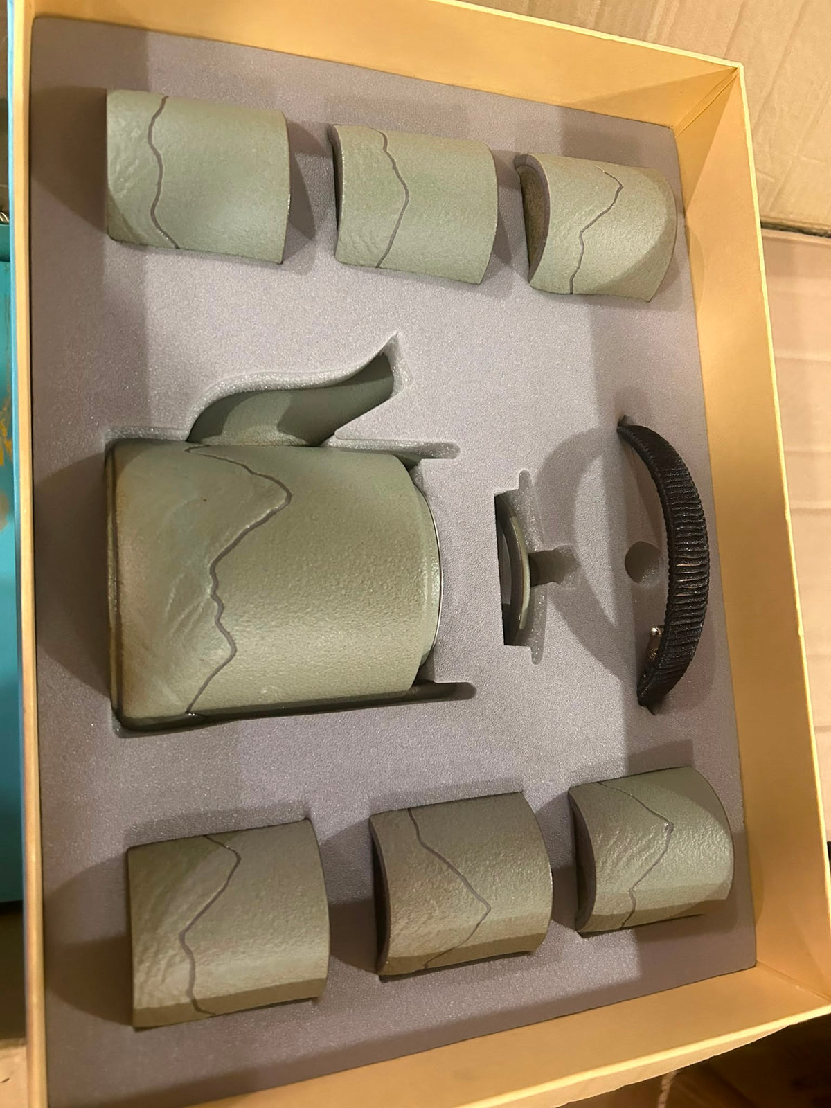 Trendiest porcelain tea set in a gift box featuring a green teapot and six cups with a mountain-inspired motif.