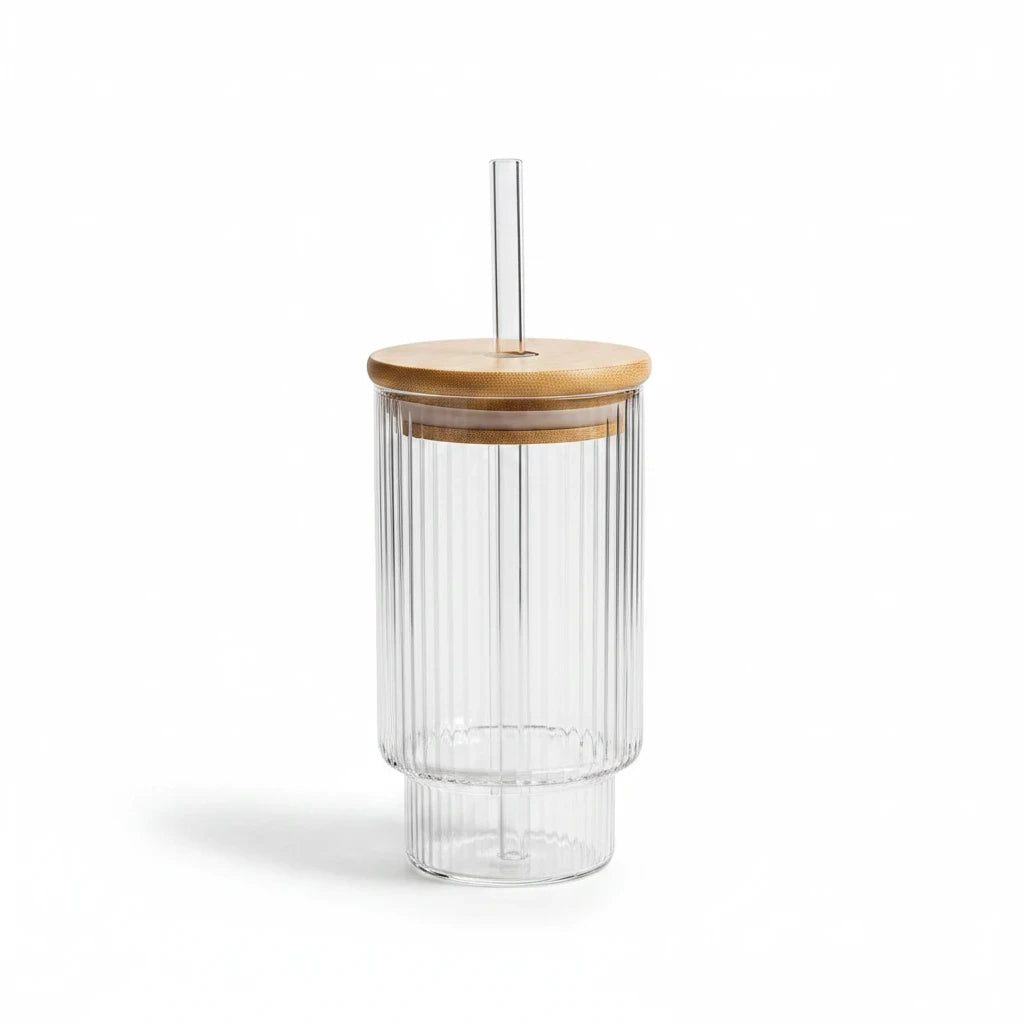 Trendiest ribbed glass tumbler with a bamboo lid and reusable glass straw on a white background