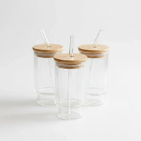 Trendiest ribbed glass tumbler set featuring three clear glasses with bamboo lids and reusable glass straws